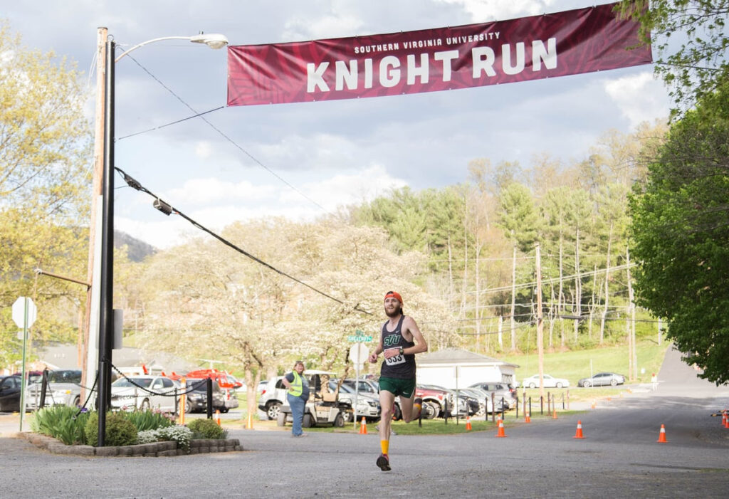 A runner passes under a red banner reading "Knight Run"