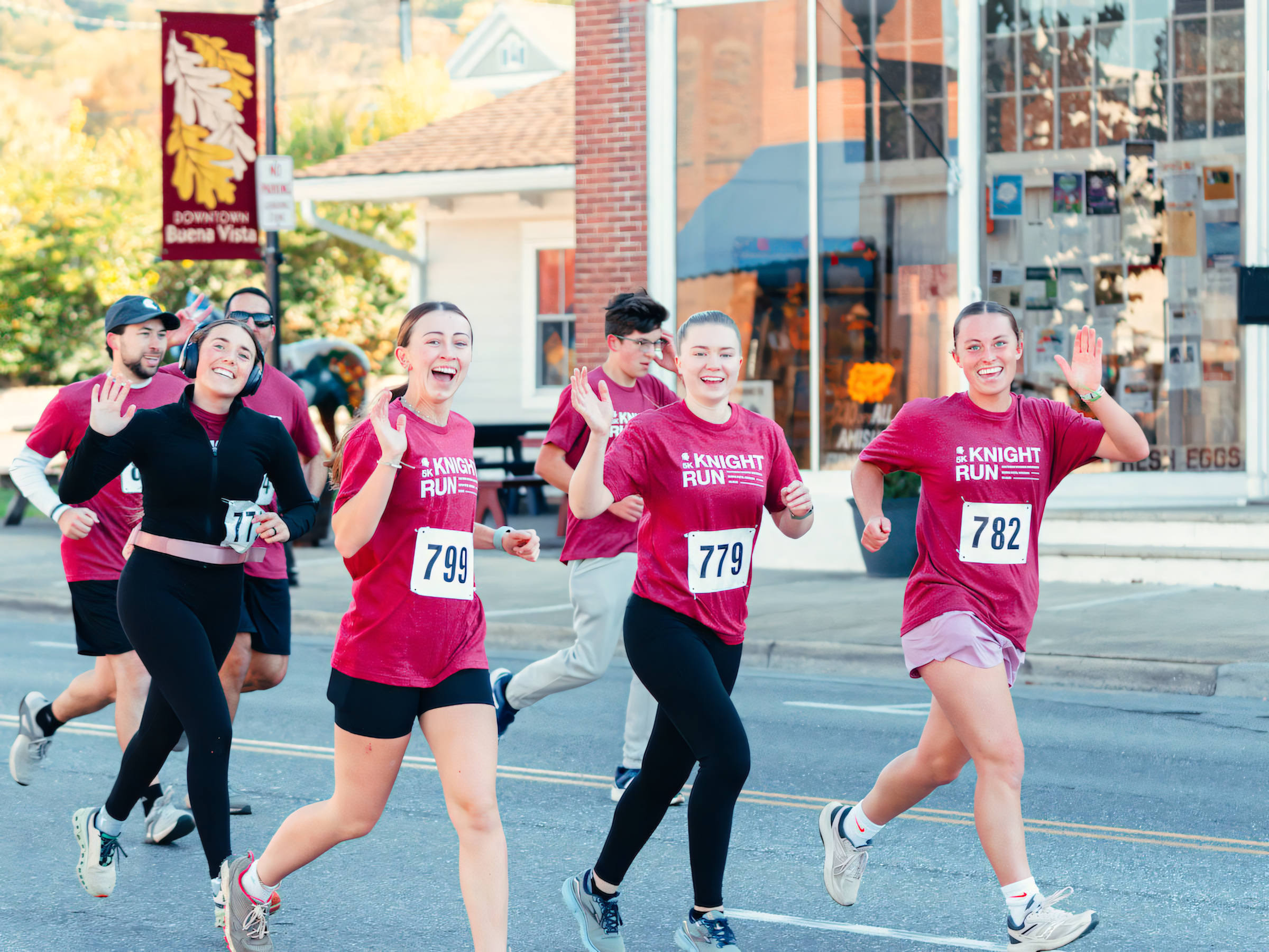 A group of runners wave as they pass