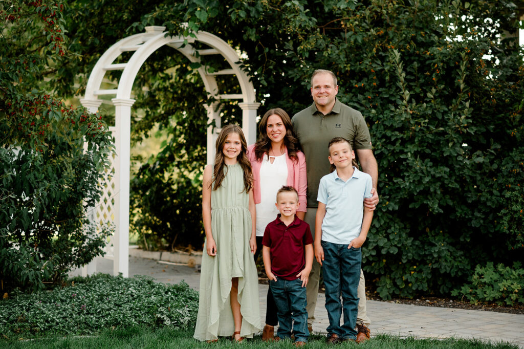 A family stands in a garden